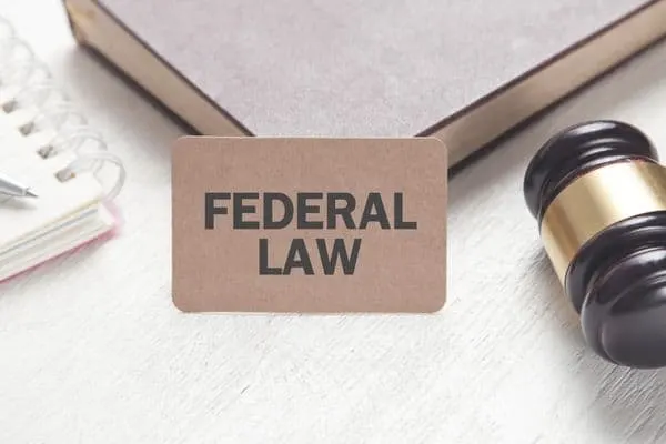 "federal law" on a desk with a gavel, book, and notepad.
